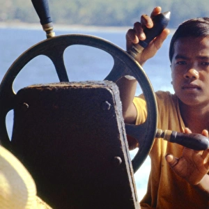Boy steering a boat, Thailand