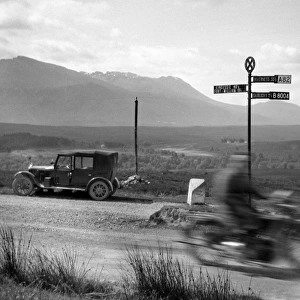 Car and motorbike passing on a road, Scotland