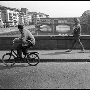 Cyclist, pedestrians, view of Ponte Vecchio, Florence, Italy