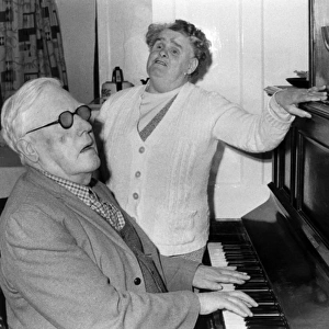Elderly blind couple having a sing-song at the piano