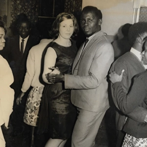 English girl and African man with other people on the dance