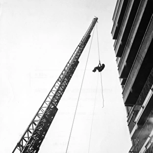 Extended ladder with man hanging in harness
