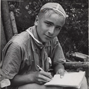 Finnish boy scout writing in a notebook