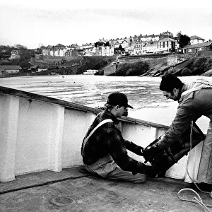 Fishermen bait a lobster pot, Newquay, Wales