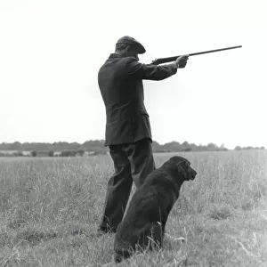 Gamekeeper with dog and gun