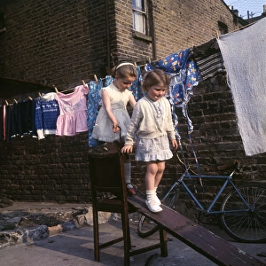 Two girls playing on planks, Balham, SW London