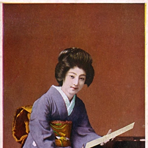 Japan - Geisha Girls kneels at her low writing table