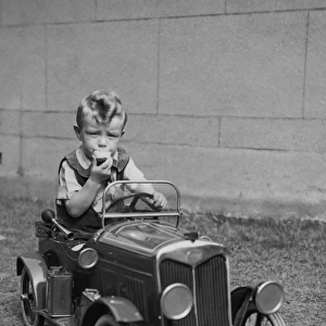 Little boy sitting in a toy car