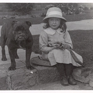 Little girl and bulldog in a garden