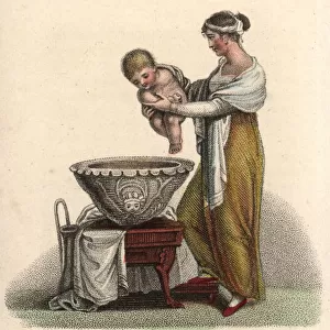 Mother putting her baby into a bath