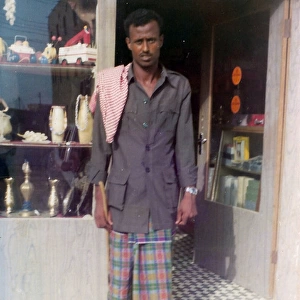 Omani man standing in front of a shop in Oman