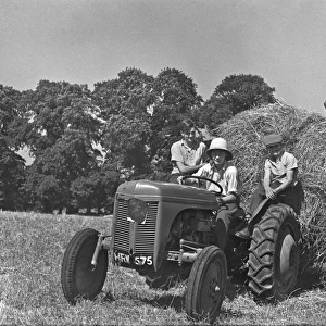 Four people with a tractor in a field