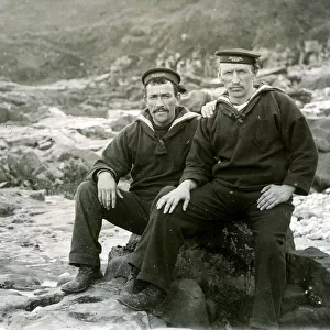 Two sailors sitting on coastal rocks