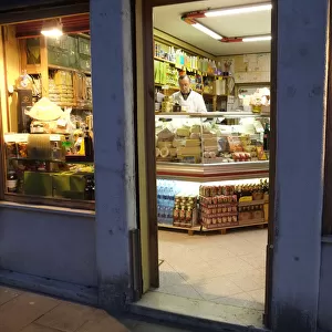 Shopkeeper in delicatessen at night, Via Garibaldi, Venice