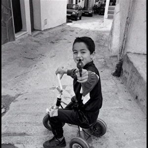 Small boy pointing a toy gun, Malaga, Spain