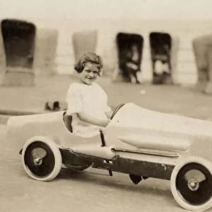 Small girl in a pedal car