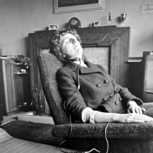 Woman asleep in an armchair with an anti-snoring machine attached to her