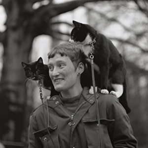 Woman with a cat on either shoulder