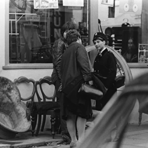 Woman police officer outside a furniture shop, London