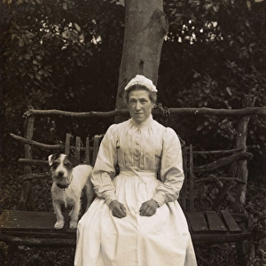 Woman with terrier on a bench in a garden