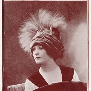 Woman wearing a fashionable velvettoque hat with plumes of feathers. Date: 1911