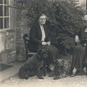 Two women and three dogs in a garden