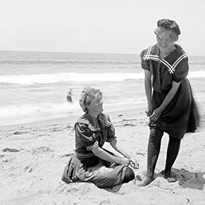 Two women in period bathing suits on the beach in America