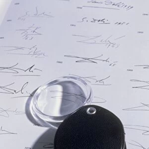Magnifying glass on sheet of real Dali signatures