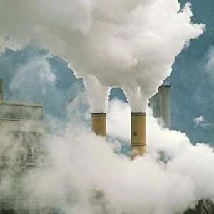 Smoking chimneys of a paper mill polluting the air