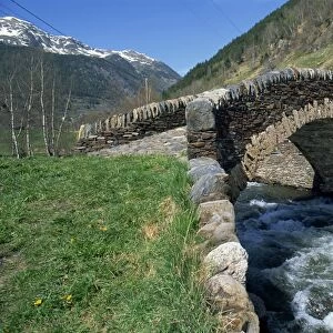Ancient stone bridge over a river in the La Malana district in the Pyrenees in Andorra