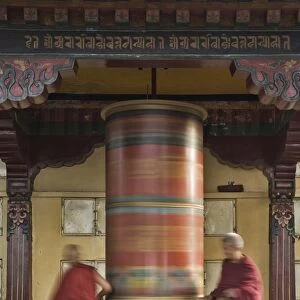 Buddhists turning prayer wheel