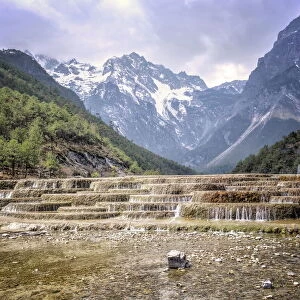 Cascading falls at Baishuihe with Jade Dragon Snow Mountain backdrop, Lijiang, Yunnan, China, Asia