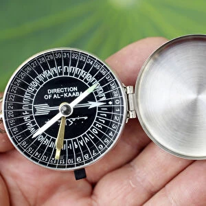 Close-up of a Muslim using a Qibla compass to indicate the direction of Al Kaaba