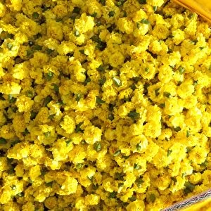 Cut yellow marigolds, weighed and bagged in cotton cloth bundle, for sale in the
