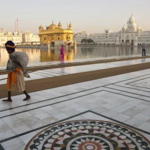 Pèlerin sikh âgé avec un paquet et une bâtonade promenant autour du bassin sacré Pèlerin sikh âgé avec un paquet et une bâtonade promenant autour du bassin sacré