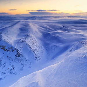 Fresh snow shaped by the cold Arctic wind blowing over mountains at dawn, Tana