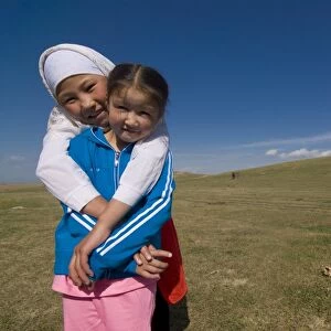 Two girls in a open field near Song Kul, Kyrgyzstan, Central Asia, Asia