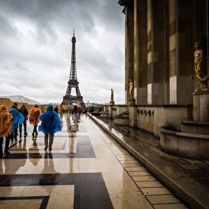 Heading towards the Eiffel Tower, tourists brave the rain in colourful ponchos at