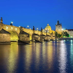 Illuminated Charles Bridge with reflections at twilight, UNESCO World Heritage Site, Prague, Bohemia, Czech Republic (Czechia), Europe