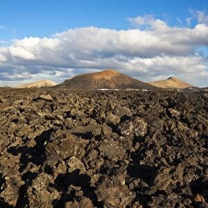 Irregular blocky lava (Hawaiian term: a a) and cinder cones of the volcanic landscape of Timanfaya National Park, Lanzarote, Canary Islands, Spain, Atlantic