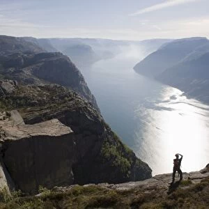 Man photographing the fjord, Preikestolen (Pulpit Rock), Lysefjord, Norway