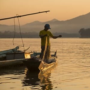 Man reeling in fishing net on Mekong River, Luang Prabang, Laos, Indochina, Southeast Asia, Asia