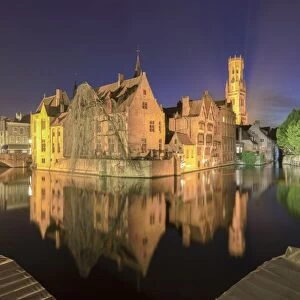 The medieval City Centre, UNESCO World Heritage Site, framed by Rozenhoedkaai canal at night