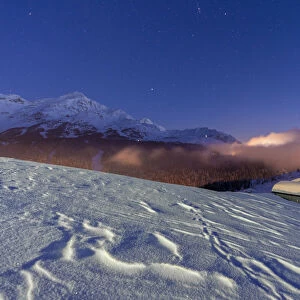 Mountain huts covered with snow under the starry winter sky, Andossi, Madesimo