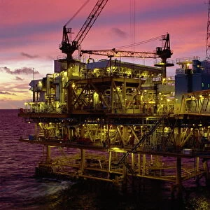 Oil rig illuminated at dusk
