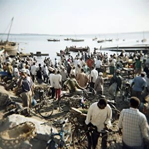 People waiting on beach for dhows to land fish, Stone Town, Zanzibar, Tanzania