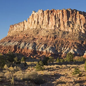 Sandstone cliffs of the Waterpocket Fold towering above Scenic Drive, sunset, Fruita