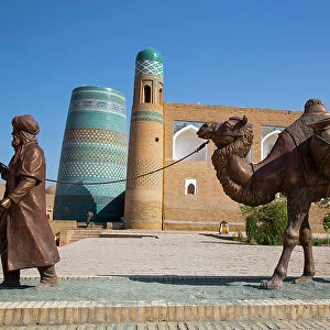Sculpture of Camel Train, Kalta Minaret in the background, Ichon Qala (Itchan Kala), UNESCO World Heritage Site, Khiva, Uzbekistan, Central Asia, Asia