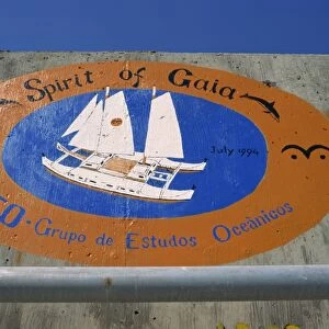 Sea wall at port decorated with pictorial souvenirs of boats visit
