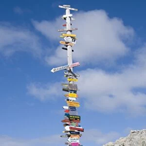 Signs with mileage to world destinations made into a totem pole, Port Stanley